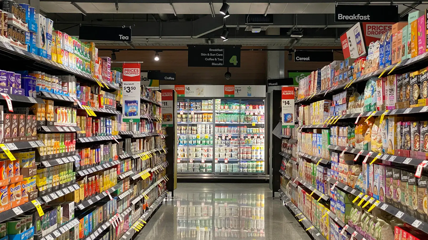 Allée de supermarché avec, au fond, des meubles frigorifiques vitrés