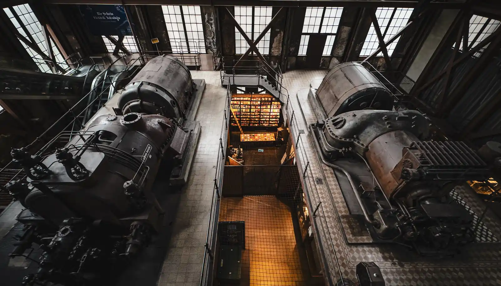Salle des machines d’une ancienne centrale électrique : turbines et alternateurs vus d’en haut