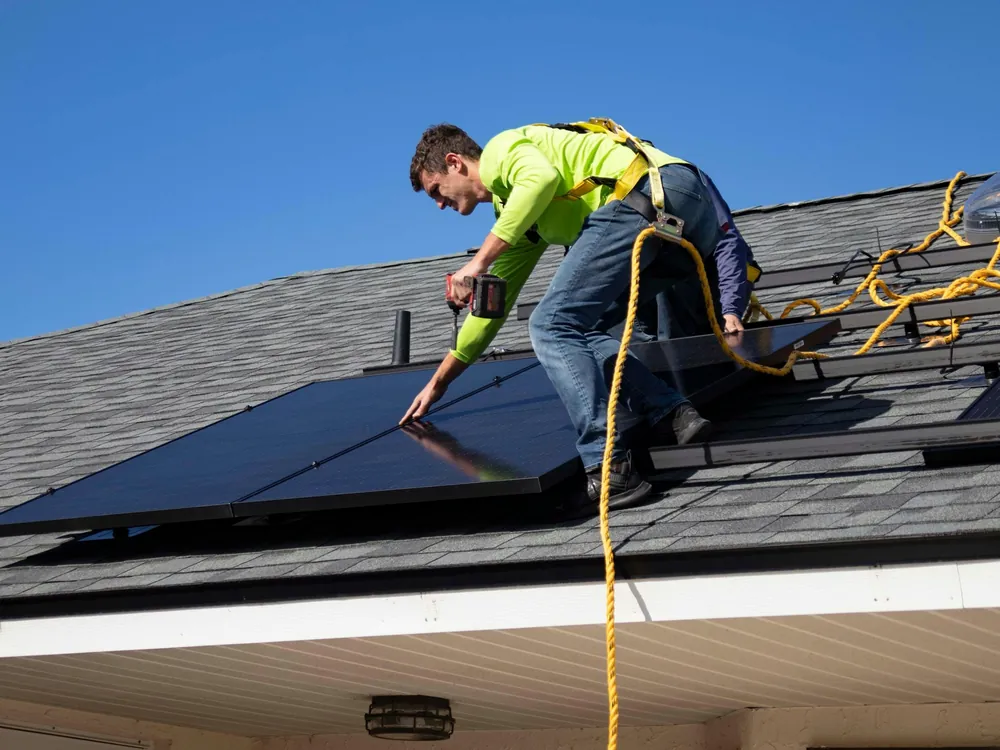 Installateur posant des panneaux solaires sur un toit